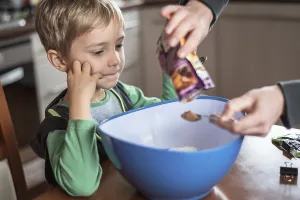 6 years old boy looking on preparing Christmas cake