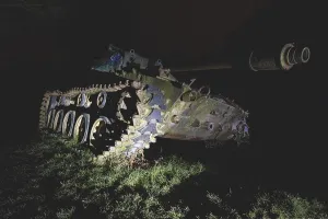 An abandoned tank with graffiti in the dark forest