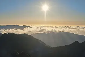 Aerial drone view of mountains over clouds near Pico Ruivo on sunset