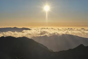 Aerial drone view of mountains over clouds near Pico Ruivo on sunset
