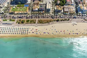 Aerial view, beach life and sunbathing with straw parasols at Playa de Palma