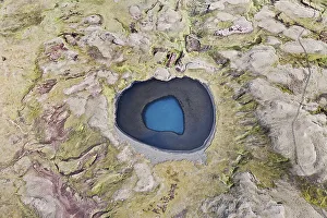 Aerial view, a blue crater lake surrounded by moss-covered mountains