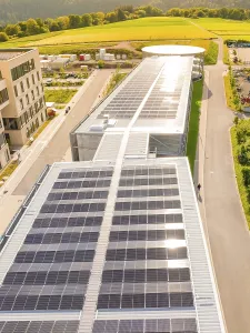 Aerial view of a building with long rows of solar panels on the flat roof
