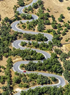 Aerial view of a curved road, car, red