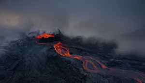 Aerial view, erupting volcano with lava fountains and lava field