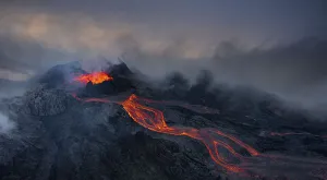 Aerial view, erupting volcano with lava fountains and lava field