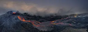 Aerial view, erupting volcano with lava fountains and lava field