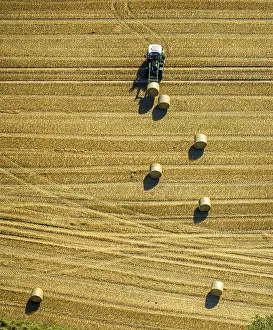 Aerial view, field work, tractor with hay bales in a field
