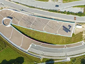 Aerial view of a green roof with solar panel and surrounding roads in urban surroundings