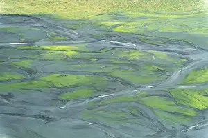 Aerial view of Iceland's braided rivers creating intricate patterns with vibrant green vegetation