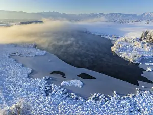 Aerial view of a lake in front of mountains