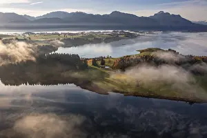 Aerial view of a lake in front of mountains in the morning light