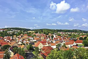An aerial view of MaBbach with a view of a picturesque town with numerous red roofs close together