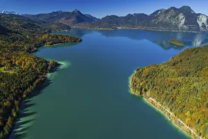 Aerial view of a mountain lake and autumnal coloured trees in the morning light