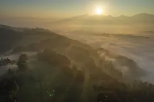 Aerial view of a mountain landscape over clouds