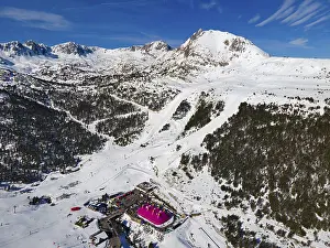 Aerial view of a mountain station with surrounding ski slopes in a winter landscape