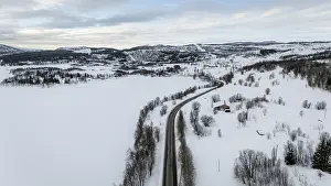 Aerial view of a serene Nordic winter landscape with snow-covered fields
