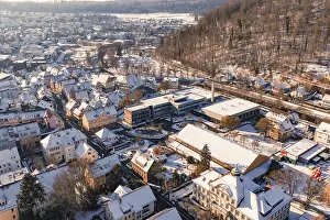 Aerial view of a snowy town surrounded by forest landscape and hills