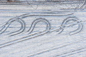 Aerial view tractor tracks on a snowy field