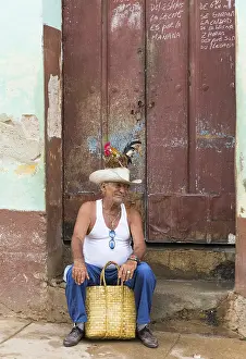 Aged Cuban man with a rooster on the head