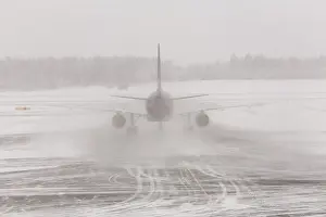 Airplane in bad weather, snow storm on snowy runway