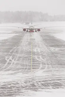 Airplane in bad weather, snow storm on snowy runway