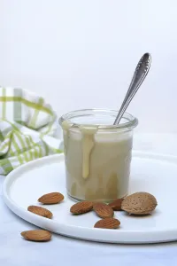 Almond cream in a jar and almonds