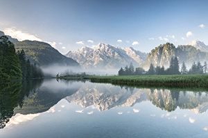 Alpine lake with reflection, fog atmosphere