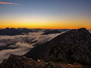 Alpine panorama at dusk, fog in the valley