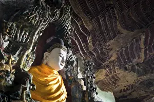Amazing view of lot Buddhas statues and religious carving on limestone rock in sacred Kaw Goon cave