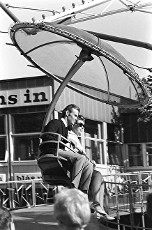 Amusement park in the 1960s. A couple is seen in one of the attractions that are offered on the grounds