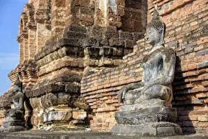 Ancient Buddha statue sitting posture around the chapel among the ruins of Wat Maha That temple at Sukhothai Historical