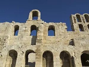 Ancient stone structure with multiple arches under a clear blue sky