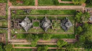 An ancient temple complex next to a city and a modern temple