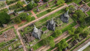 An ancient temple complex next to a city and a modern temple