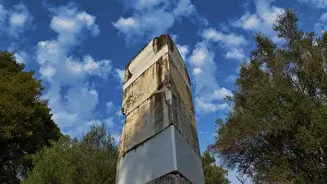 Ancient wall against cloudy sky and surrounded by trees