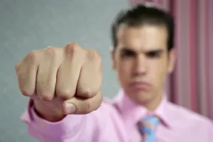 Angry aggresive businessman with fist closeup to camera