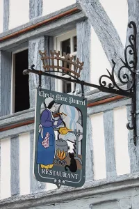 Artfully decorated restaurant sign on a traditional half-timbered house