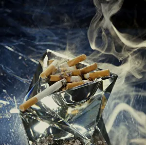 Ashtray with smoking cigarette butts