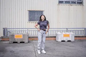 Asian female young dancer performing passionately an urban dance in the city in an industrial parking