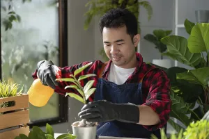 Asian gardener in a denim apron