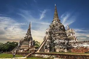 Asian religious architecture. Ancient Buddhist pagoda ruins at Wat Phra Sri Sanphet temple under sunset sky