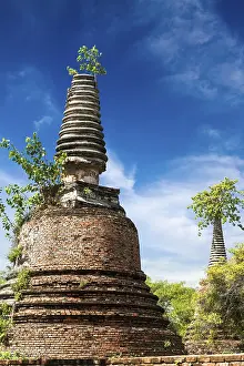 Asian religious architecture. Ancient ruins with growing trees under blue sky