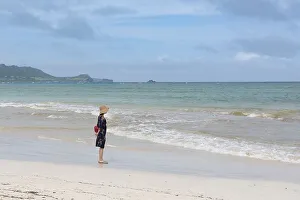 Asian woman at the beach looking into the ocean in Hawaii