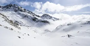 Atmospheric clouds in a wintry mountain landscape