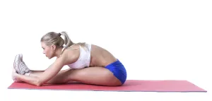 Attractive sporty girl doing exercises on mat in studio