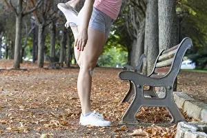Attractive sporty woman warming up in a park
