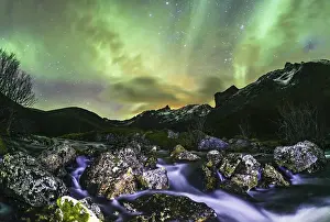 Aurora borealis over landscape with small river near the Sethaugelva lake in Tromvik