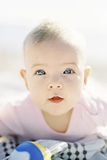 Baby lies on his tummy on the beach. Portrait