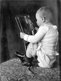 Baby reads magazine and sits on the pot ca
